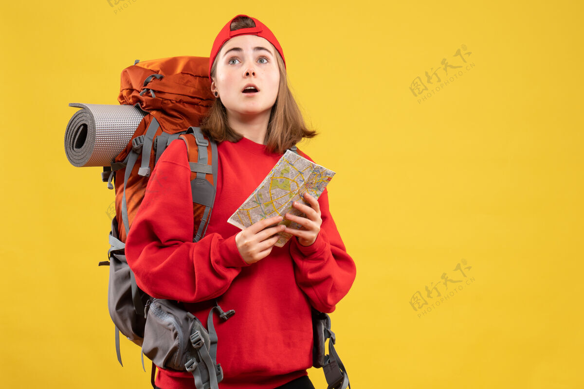 背包前视图美丽的女徒步旅行者与红色背包举行地图看成人正面地图