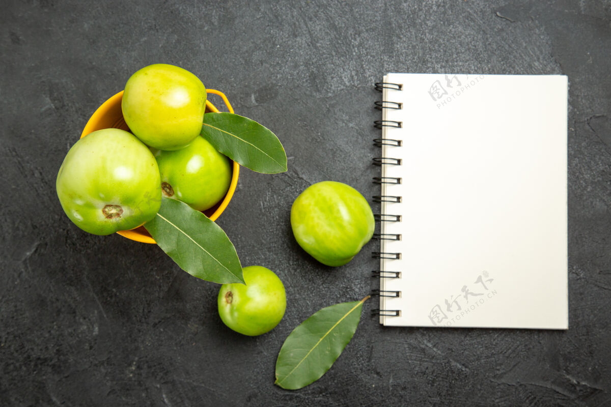 深色顶视图绿色西红柿桶和海湾叶笔记本和西红柿在黑暗的背景柠檬农产品多汁