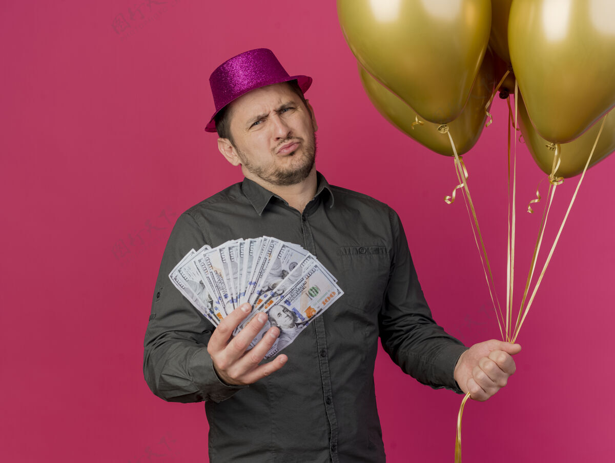 不愉快一个戴着粉红色帽子 拿着气球的年轻人 手里拿着现金 被隔离在粉红色的气球上派对戴着气球
