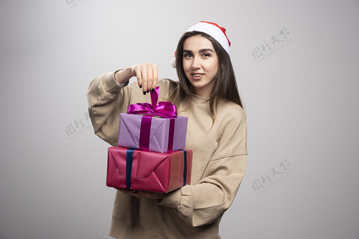 年轻拿着两份圣诞礼物的年轻女子抱着盒子漂亮