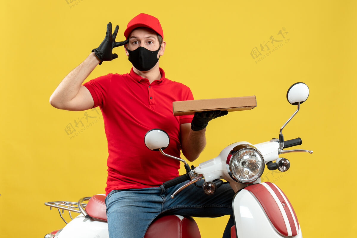 表演顶视图混乱的快递员身穿红色上衣 戴着帽子手套 戴着医用面罩 坐在滑板车上显示秩序手套摩托车坐