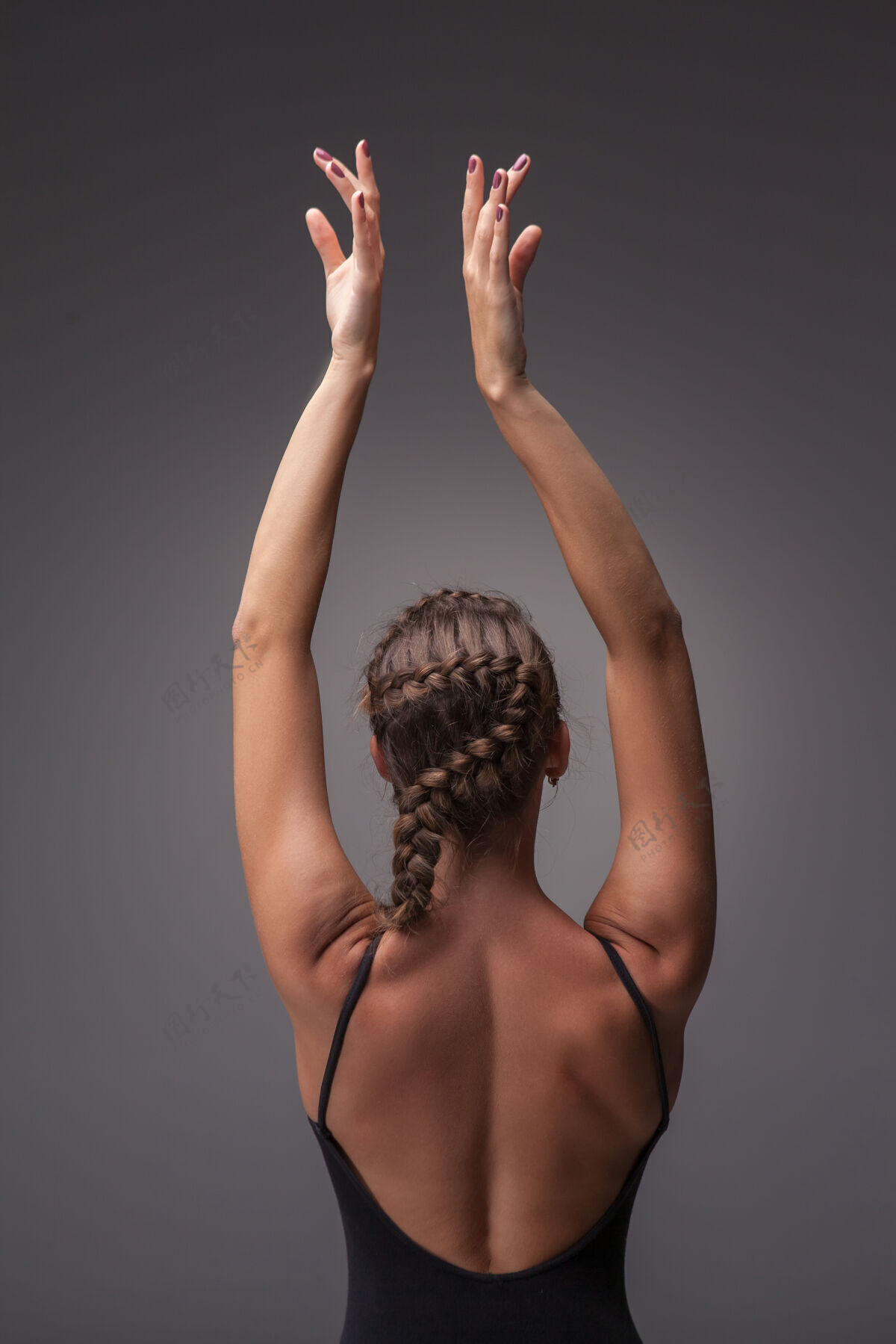 健身年轻漂亮的现代风格舞蹈演员在灰色背景下摆姿势从后面看体操芭蕾舞演员平衡