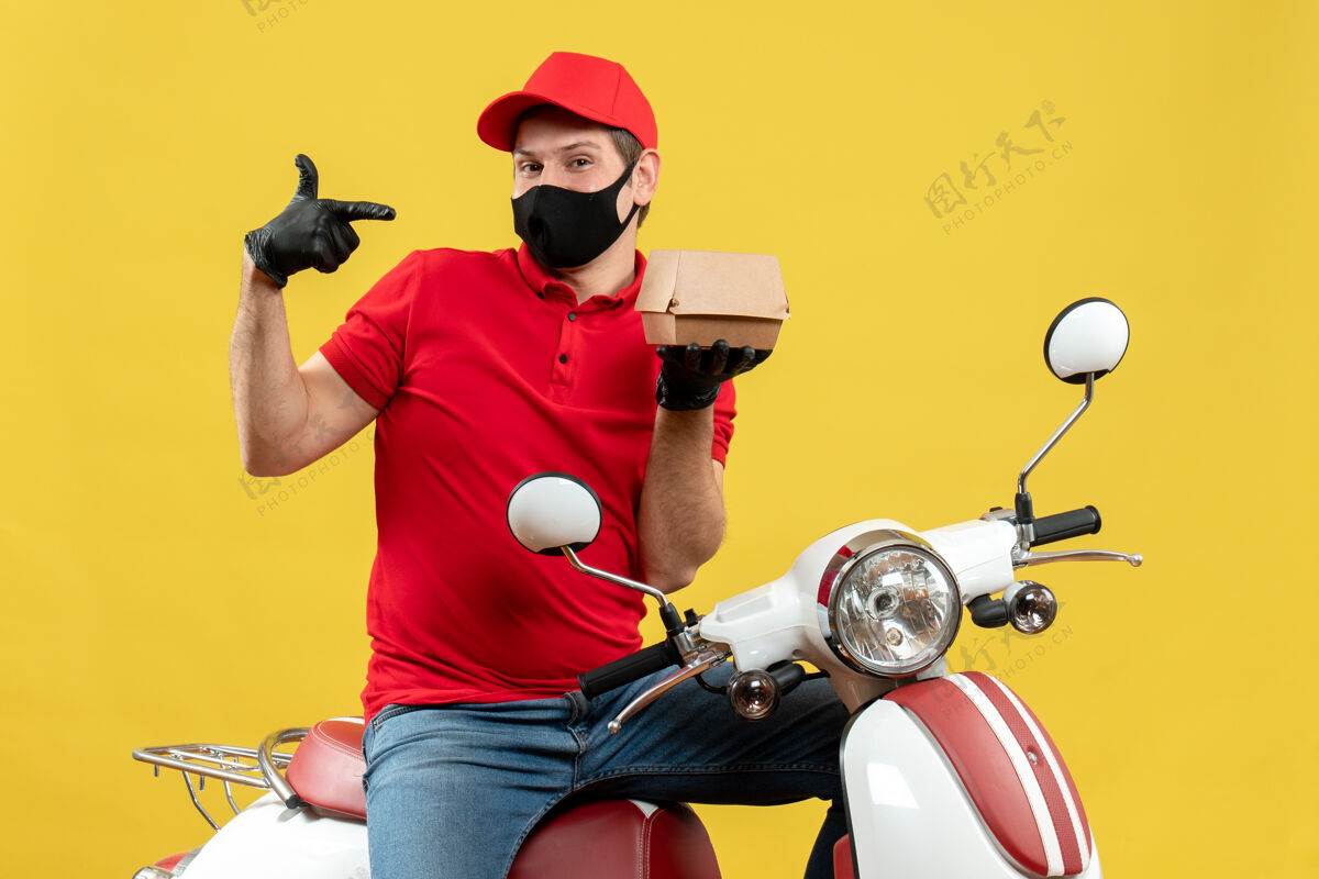人顶视图自信的送货员穿着红色上衣 戴着帽子手套 戴着医用面罩 坐在滑板车上显示秩序命令表演头盔