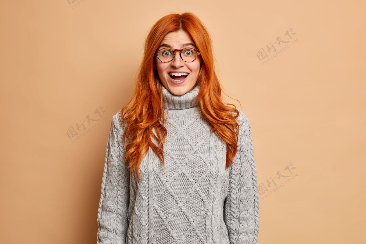 乐观喜出望外的红发女人张大了嘴巴 不敢相信她穿着针织毛衣突然成功了快乐红色女人