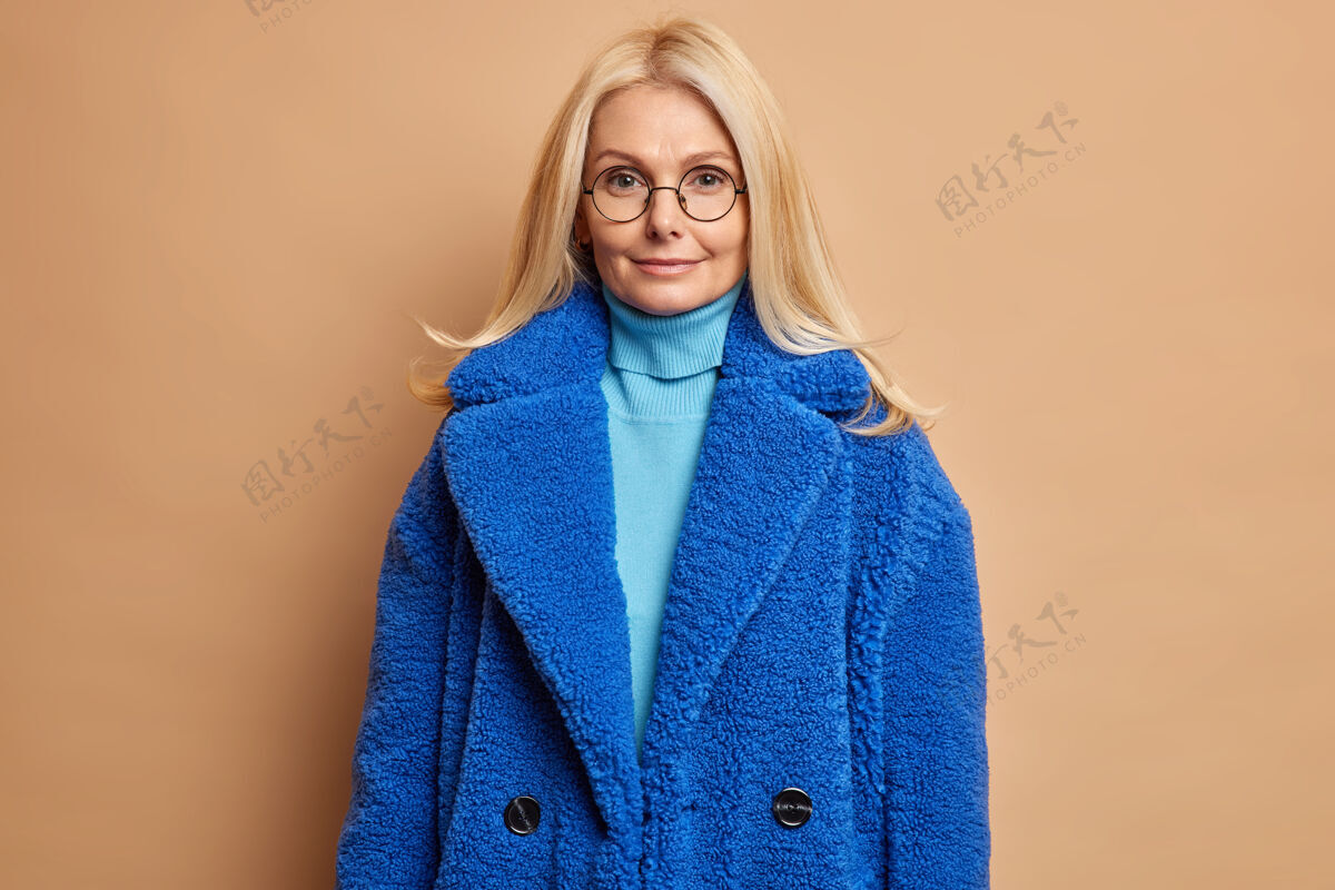 女人严肃的金发碧眼女人 穿着蓝色皮草外套 逛街买了时髦的冬季外套 表情迷人 直接满足了喜悦享受支架