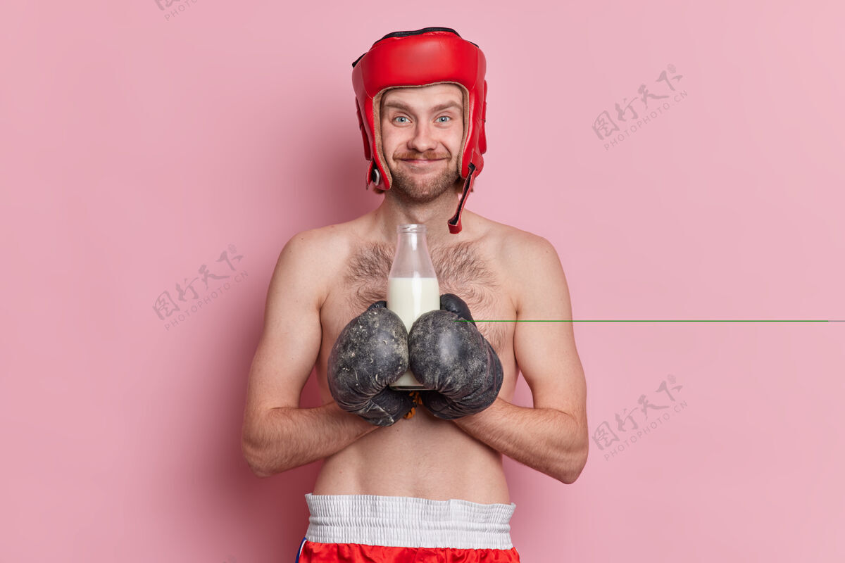运动员人们运动健康饮料的概念开朗的拳击手戴防护帽拳击手套瘦赤膊满意