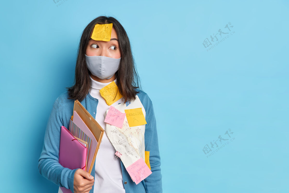 贴纸一个亚洲女人坚持用提醒笔记戴防护面具 以保护自己免受冠状病毒的感染她做文书工作室内一次性惊喜