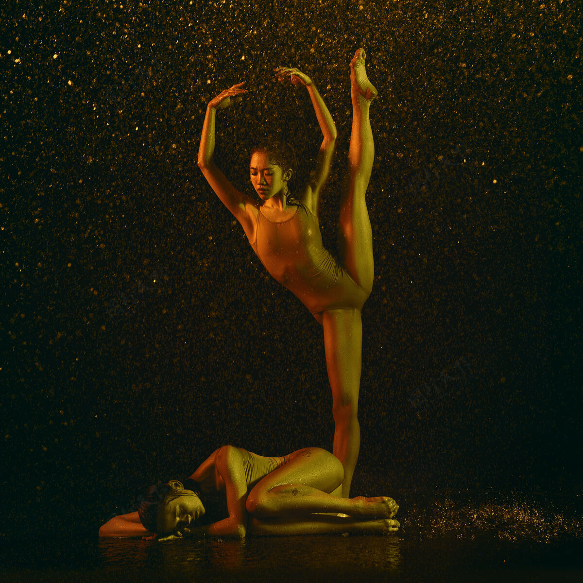 下降睡觉两个年轻的女芭蕾舞演员在水滴和浪花下白种人和亚洲模特在霓虹灯下一起跳舞芭蕾舞和当代舞蹈概念创意艺术照片身体喷雾编舞