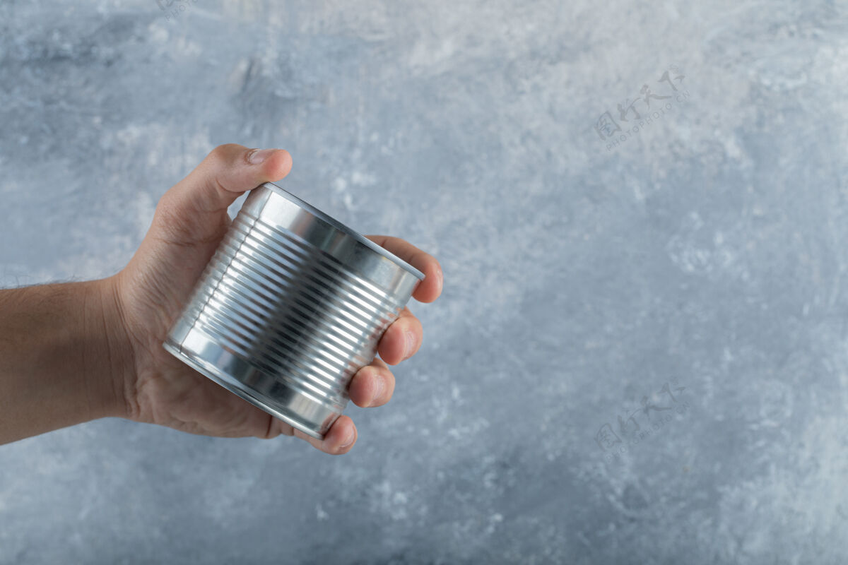 罐一只手拿着金属罐放在大理石上罐金属空的