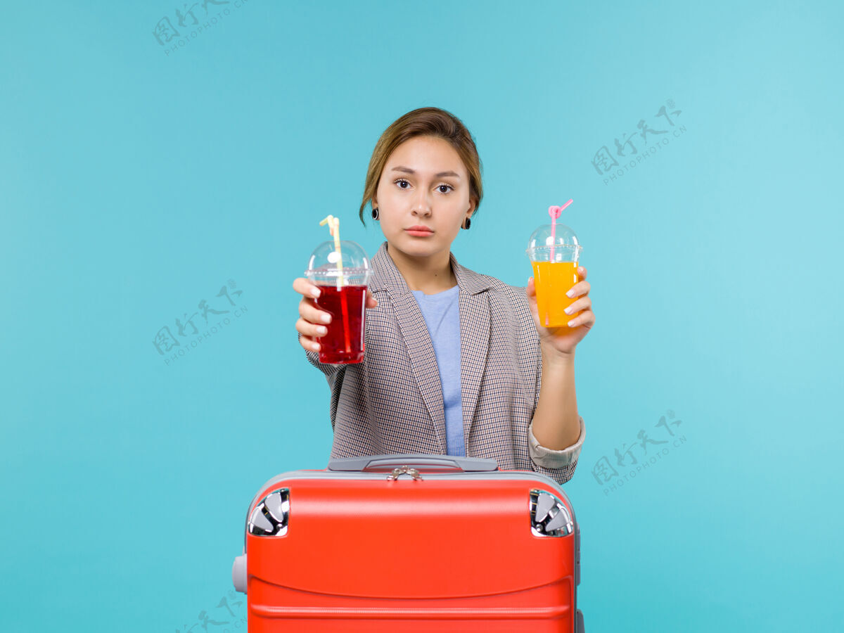 航行前景度假中的女性手持新鲜饮料在蓝色地板上旅行度假旅行海上飞机风景前方给予