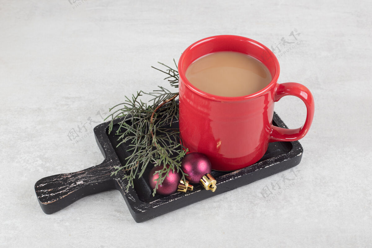 球一杯咖啡和圣诞饰品在黑暗的董事会装饰营养热