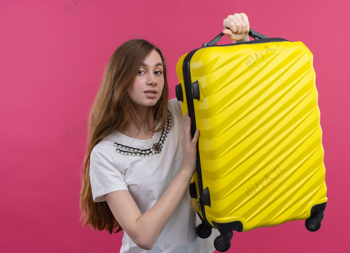 年轻印象深刻的年轻旅行家女孩提出了孤立的粉红色空间与复制空间手提箱印象旅行者手提箱
