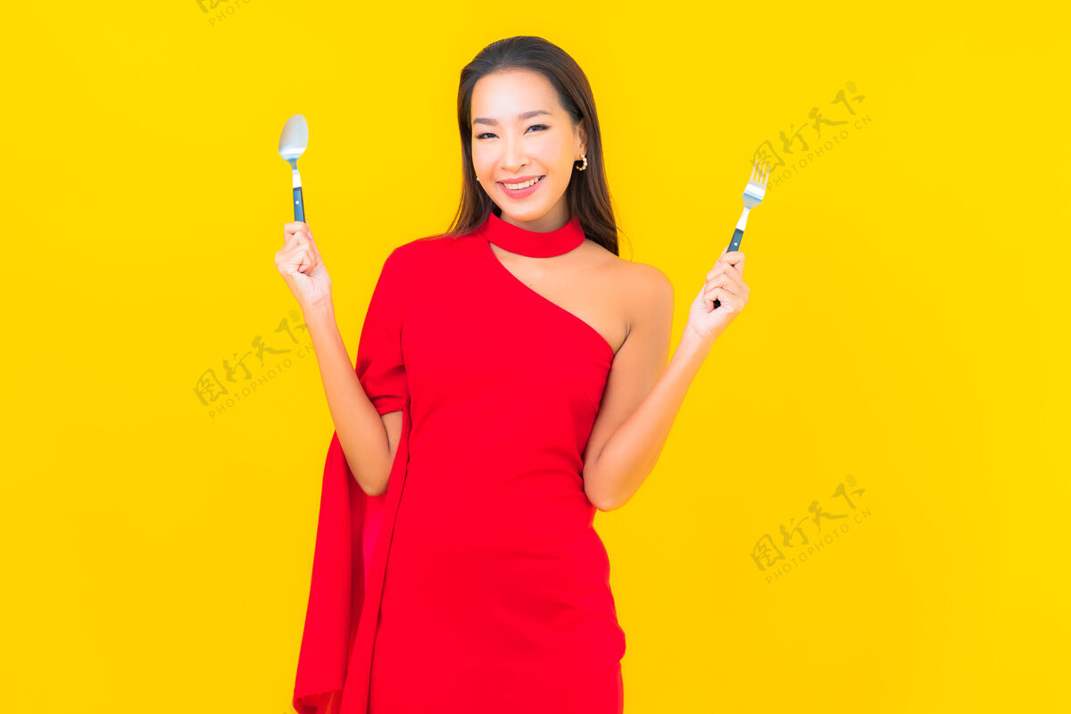 美丽肖像美丽的亚洲年轻女子用勺子和叉子准备吃饭手饮食厨房