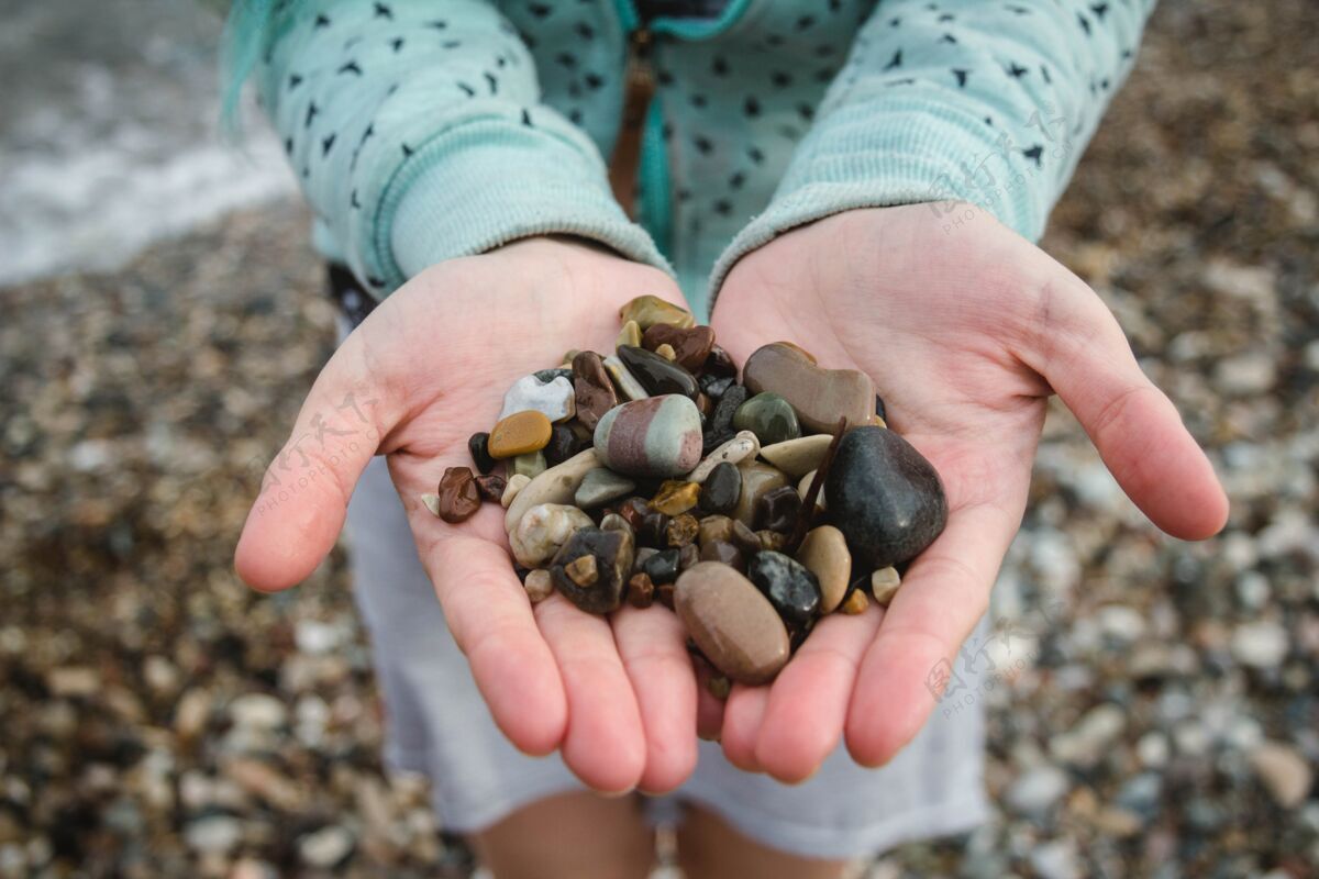 景观在沙滩上抱着各种颜色的小鹅卵石美丽旅游岩石