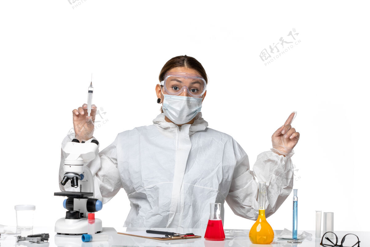 制服正面图：穿着防护服 戴着口罩的女医生拿着注射用的白色背景病毒药物covid-大流行男性注射西装
