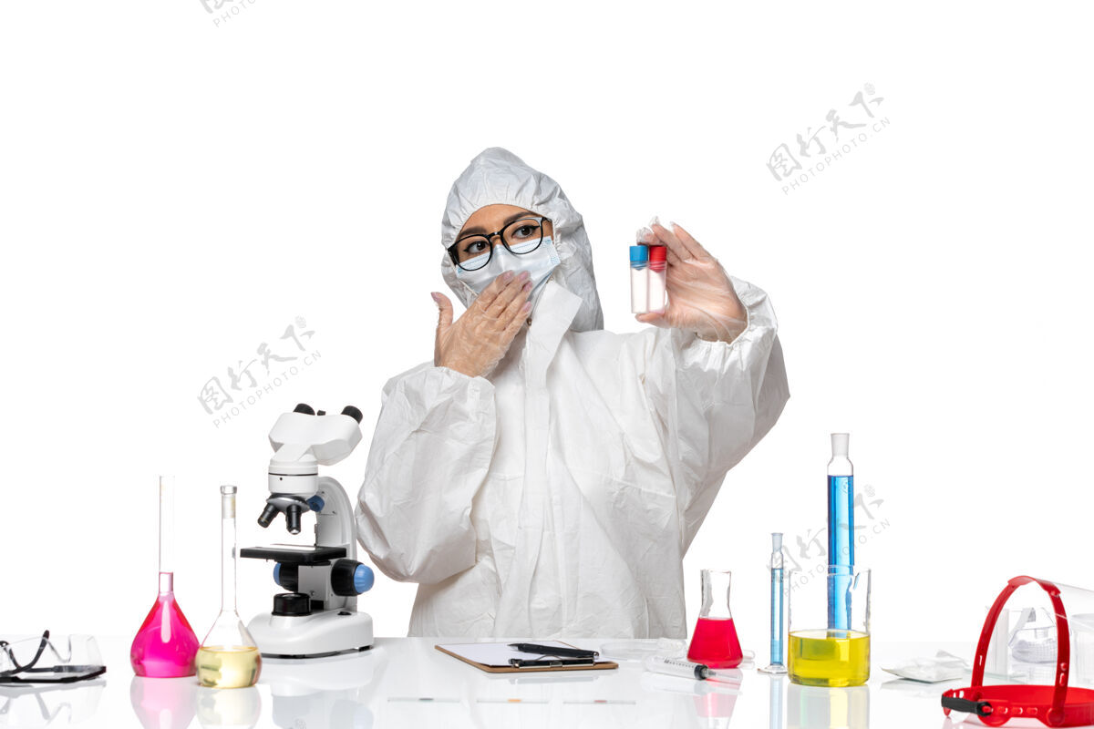 白色正面图穿着特殊防护服的女化学家拿着空瓶子站在白色地板上健康病毒化学面罩持有保护