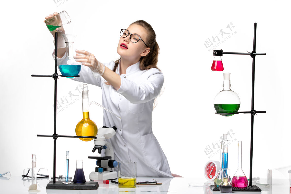 实验室前视图身着医疗服的女化学家在工作过程中用白色背景上的溶液化学大流行的冠状病毒化学过程视野