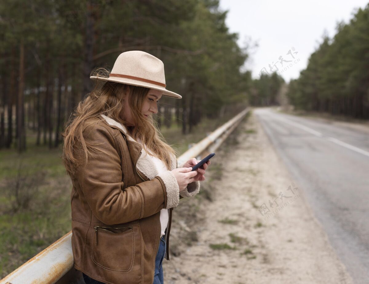 旅游带着智能手机的中枪女人户外放松休闲