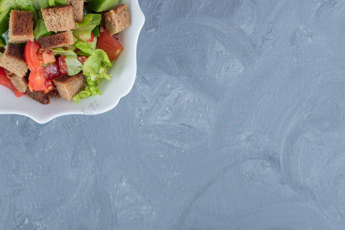 木板一碗蔬菜沙拉 番茄 黄瓜 生菜和干皮放在大理石桌上风味复制空间美味