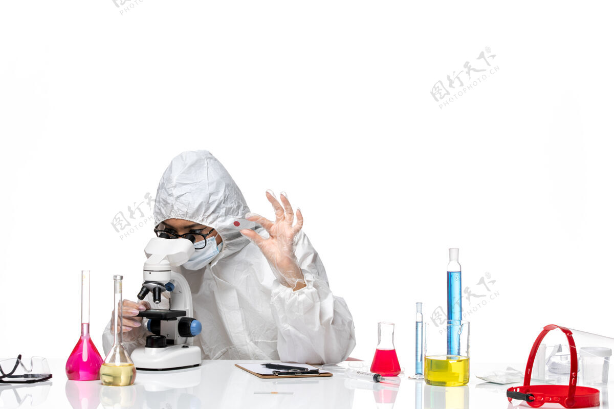 化学前视图穿着特殊防护服的女化学家正在检查白色背景病毒化学covid上的样本-大流行健康大流行工作医生
