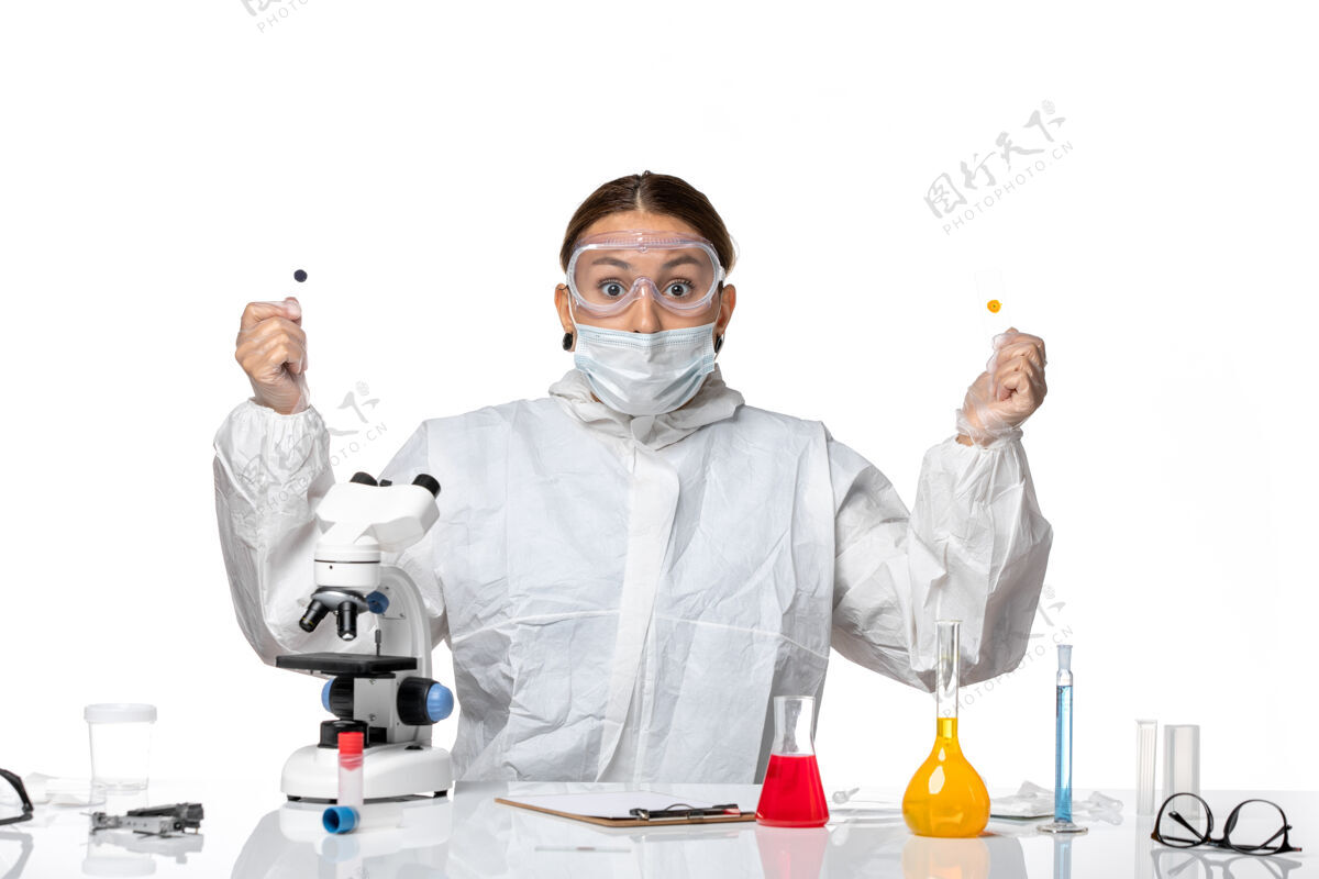 药品正面图女医生穿着防护服 戴着口罩 拿着白色背景的样本医学健康大流行病毒冠状病毒实验室外套套装视图