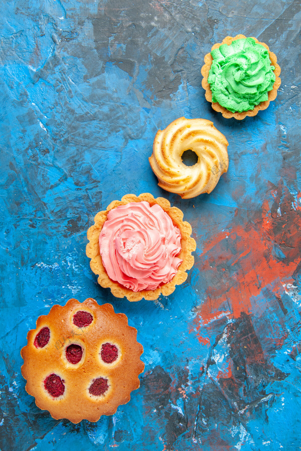 花斜排树莓蛋糕小馅饼饼干蓝色表面俯视图桌子花瓣饼干