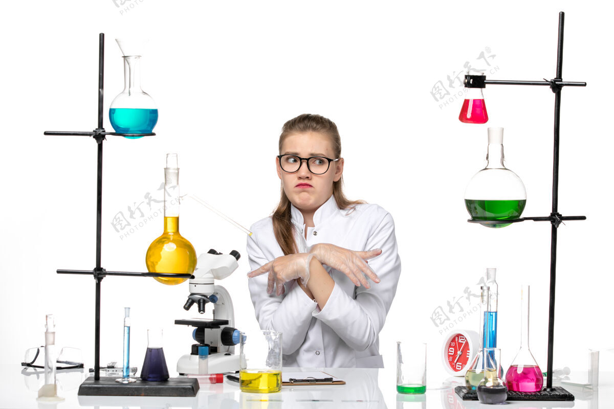 化学前视图穿着医疗服的女化学家坐在白色背景上 用溶液冲洗化学冠状病毒实验室医生坐