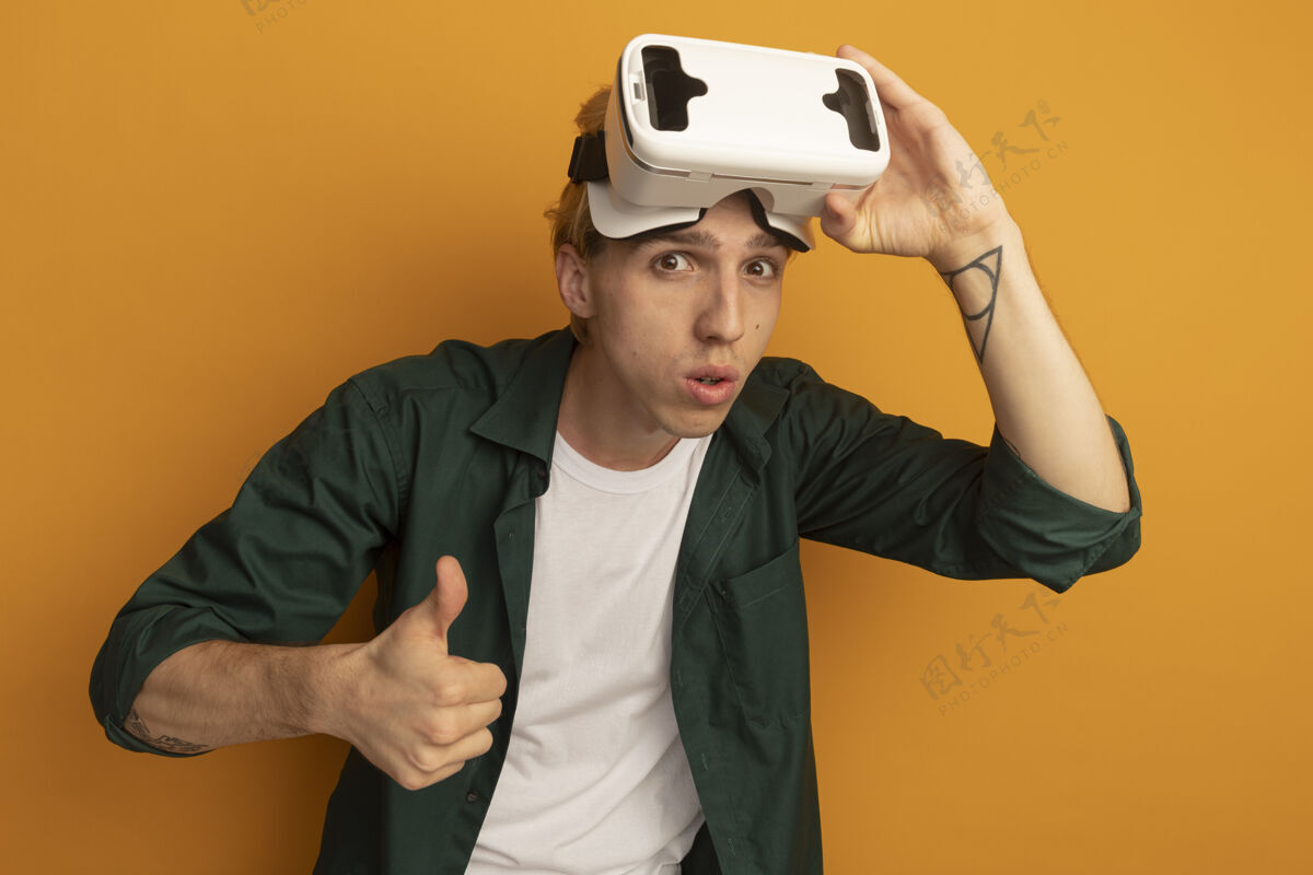 虚拟现实耳机年轻的金发男孩穿着绿色t恤和vr头戴式耳机大拇指向上游戏黄色男人