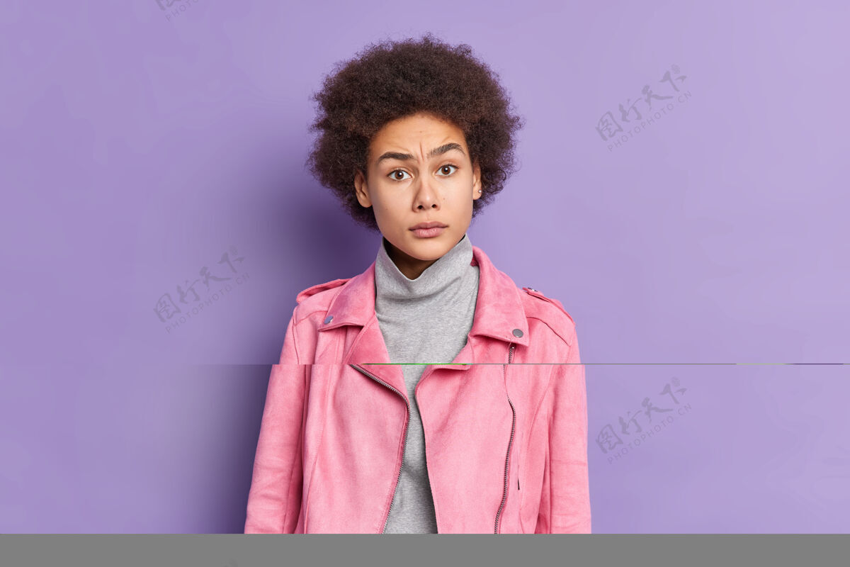 惊喜迷惑不解的年轻美籍黑人女子穿着时尚的粉色夹克 对某事反应不满表达夹克非洲