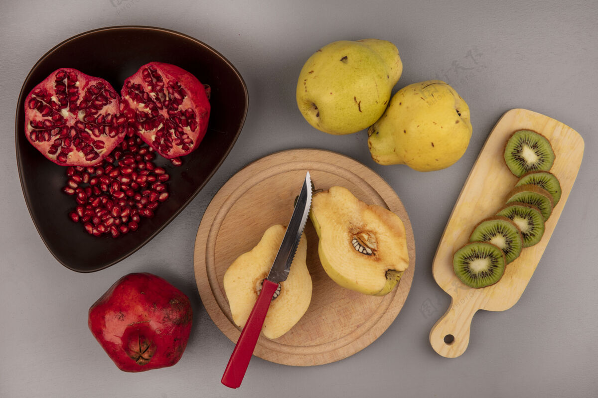 观点木制厨房板上新鲜的半切木瓜的俯视图 木制厨房板上的碗上有石榴和猕猴桃片一半食谱板