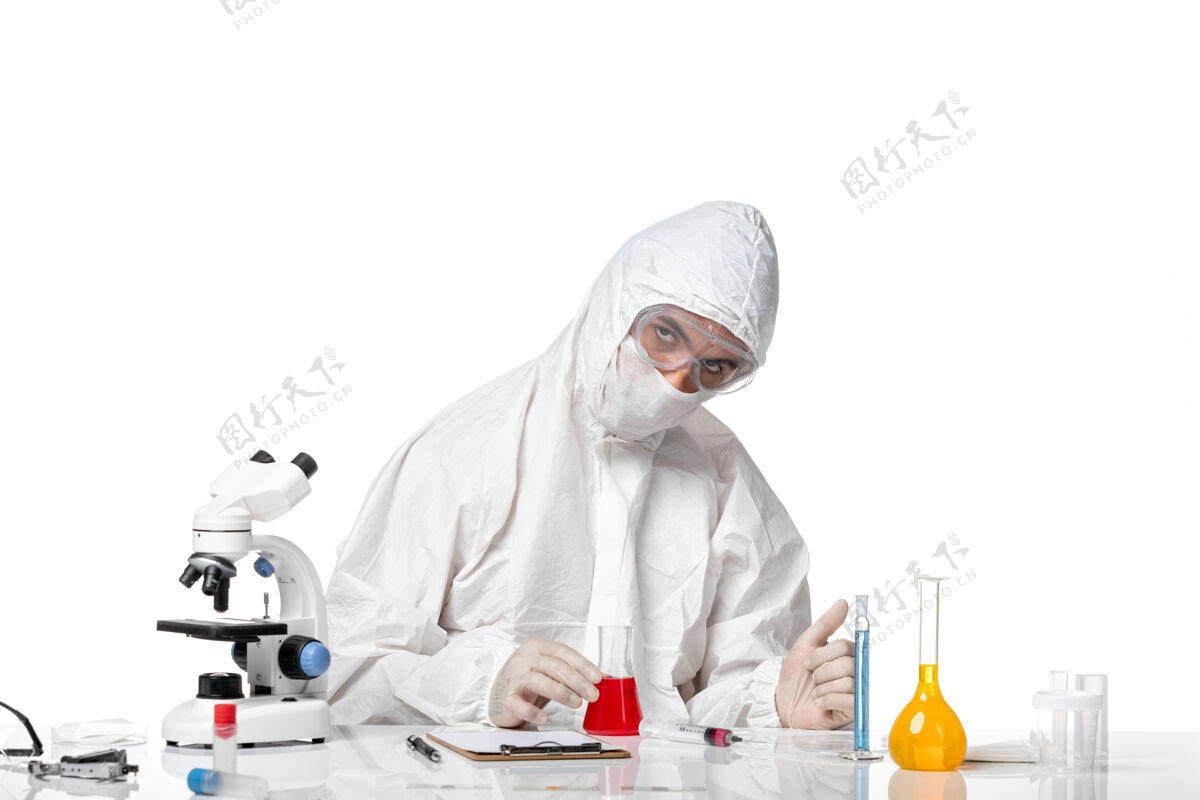 到期正面图：男医生穿着防护服 戴着面罩 因为白色空间上有一个装有红色溶液的瓶子化学面具视图