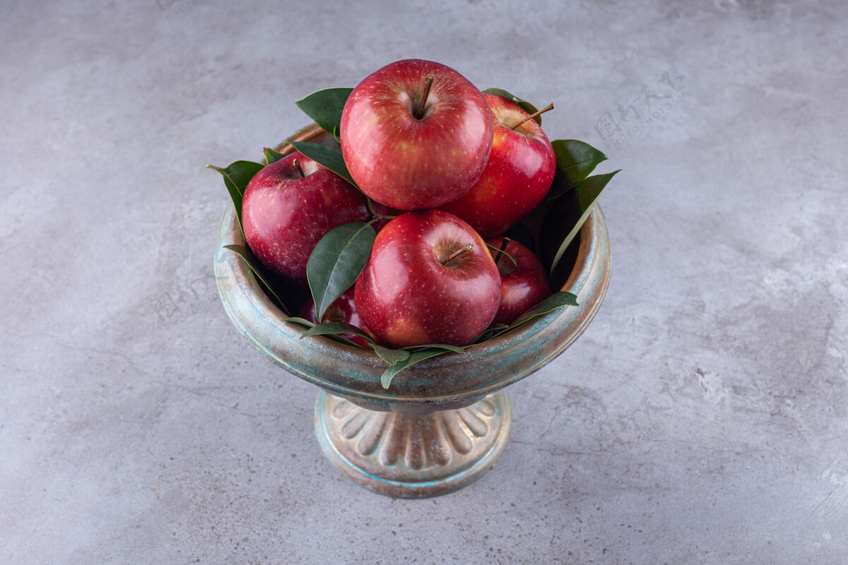 苹果金属碗 石头表面有闪亮的红苹果新鲜有机叶