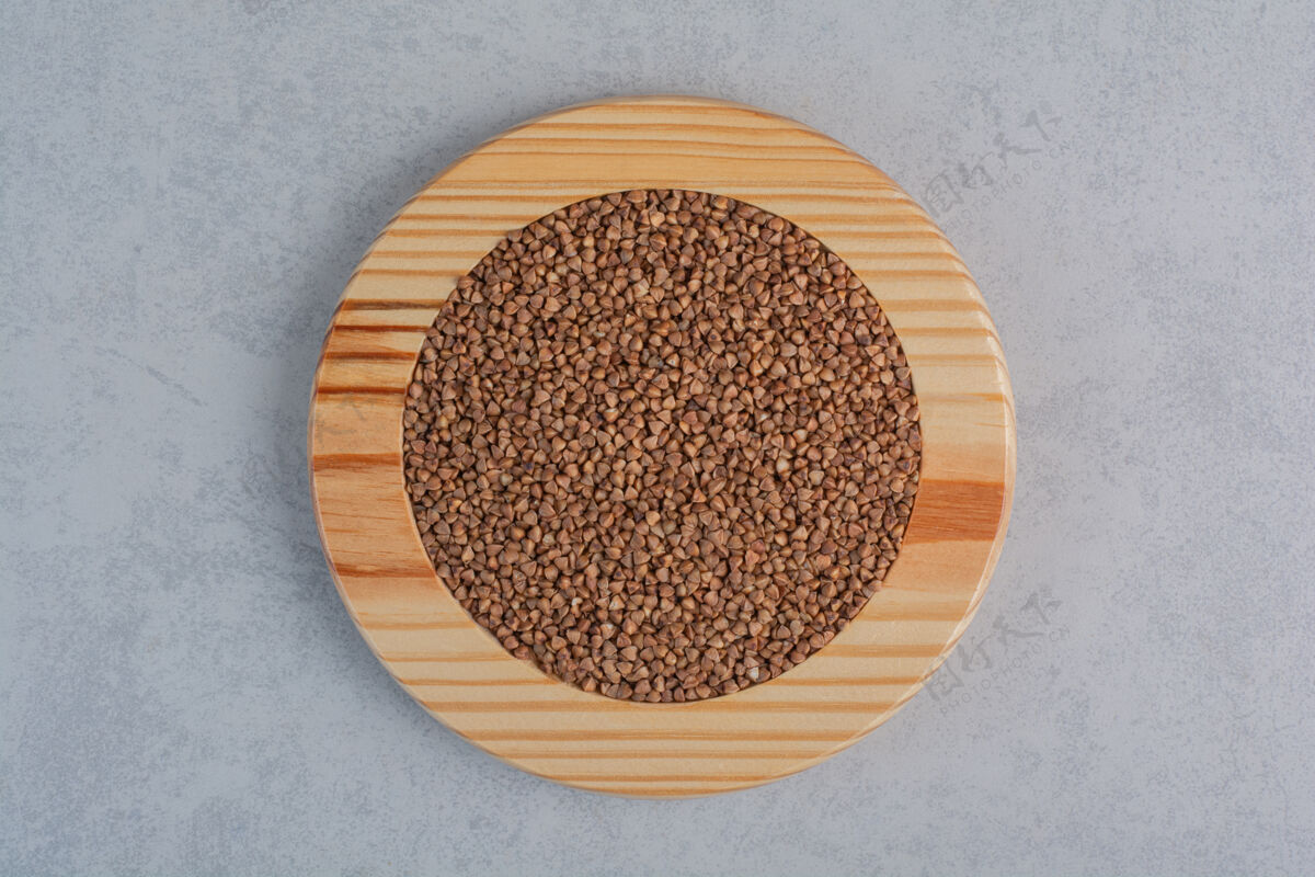 谷类荞麦堆在大理石表面的木板上荞麦碳水化合物饮食