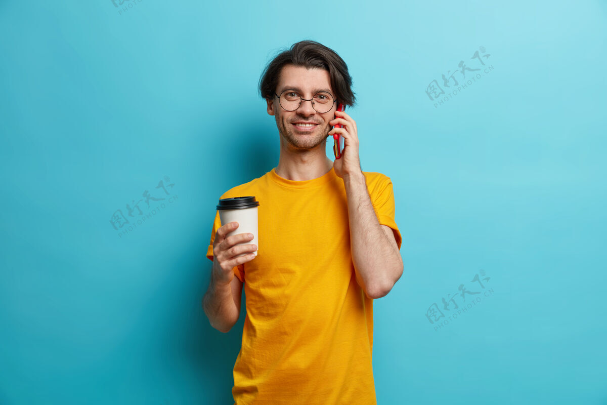 电话帅哥的照片成年欧洲男人通过智能手机打电话喝咖啡去黄色男性抱着
