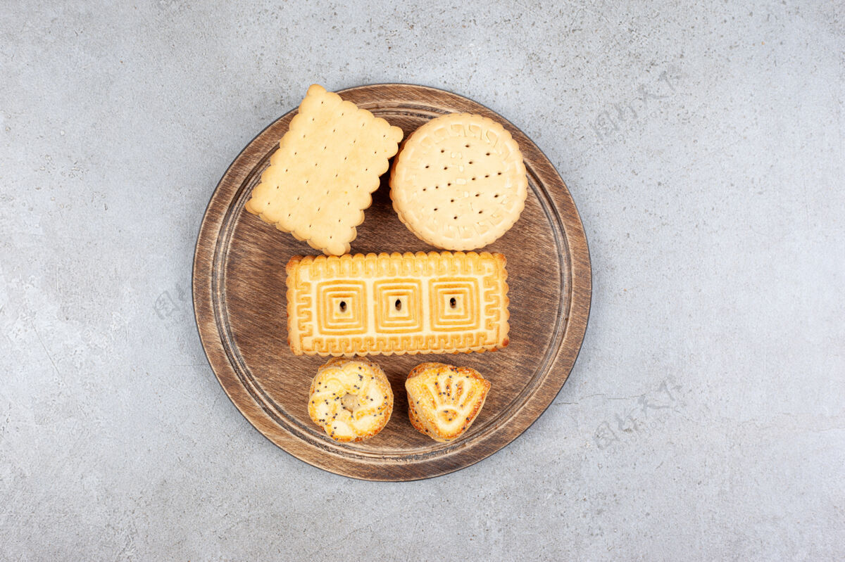 甜点各式各样的饼干放在大理石背景的木板上高质量的照片饼干饼干垃圾食品