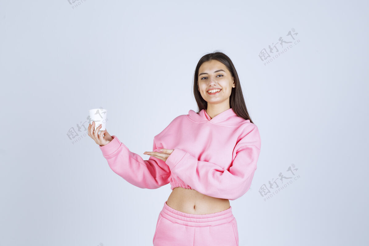 介绍穿着粉色睡衣的女孩拿着咖啡杯指着什么东西女人服装人