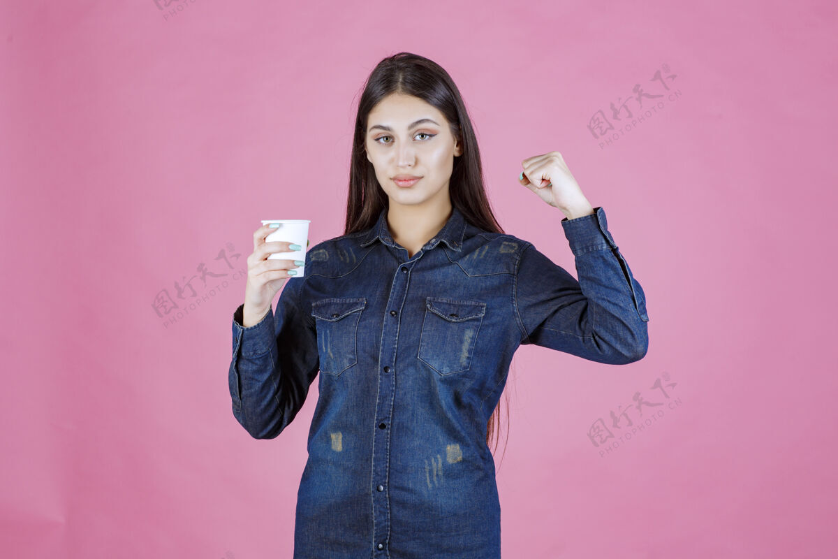 姿势穿着牛仔衬衫的女孩喝着咖啡 感觉很有力量装备人休闲