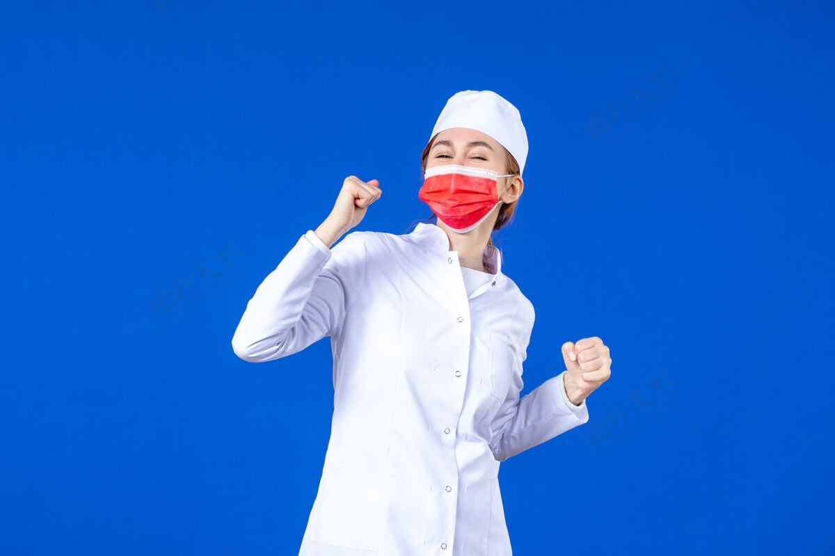 男人正面图：身着医疗服的年轻护士 戴着蓝色的红色防护面具医院医疗衣服