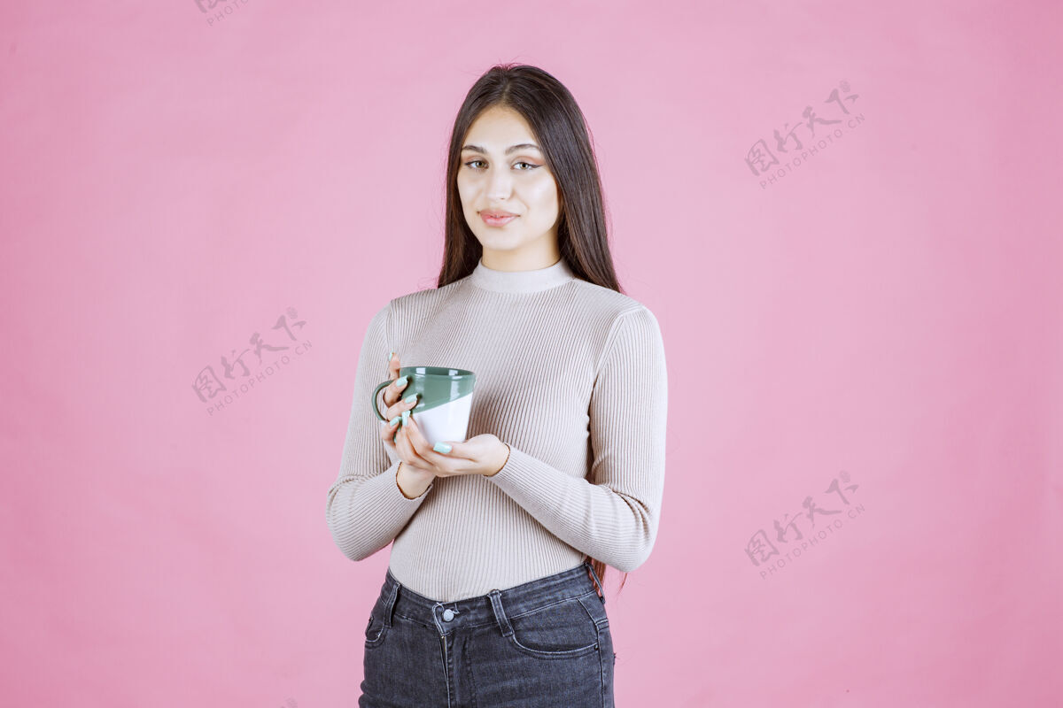 热女孩拿着一个白绿色的咖啡杯 感觉很积极巧克力人女人