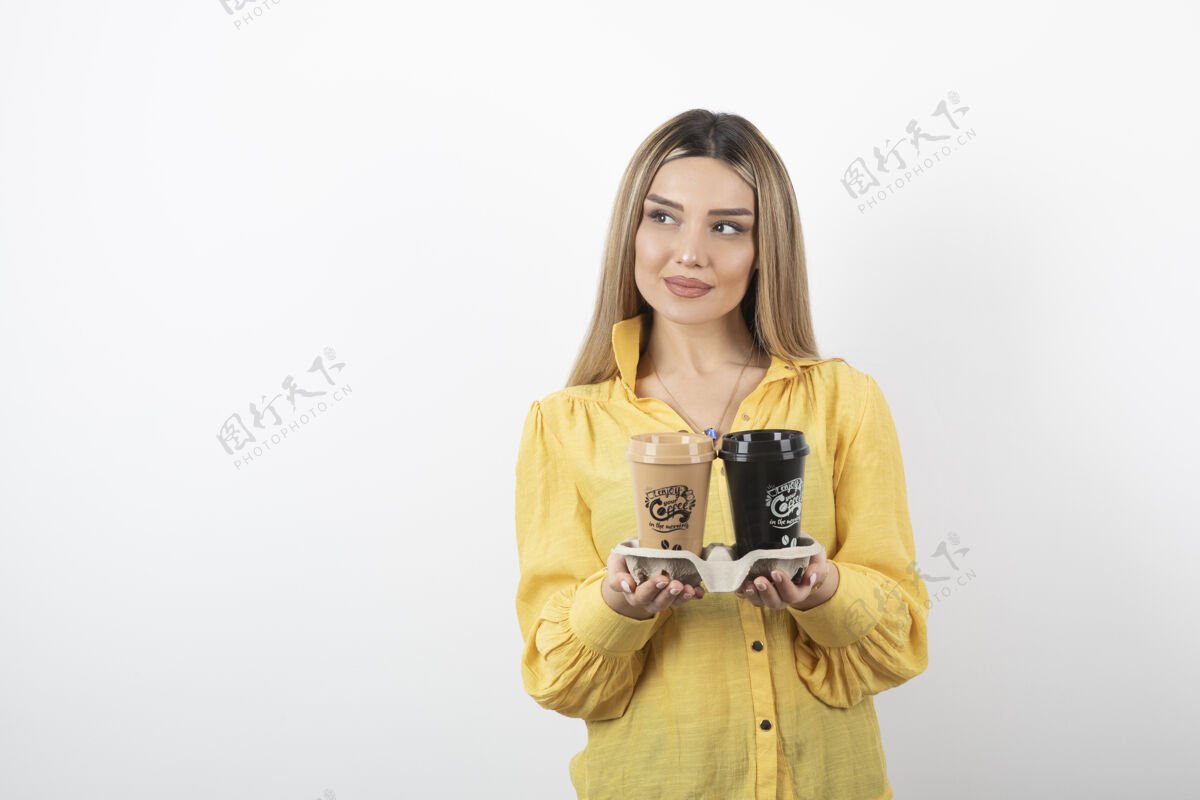 人物一张年轻女子的肖像 她拿着几杯咖啡摆姿势模特站着茶