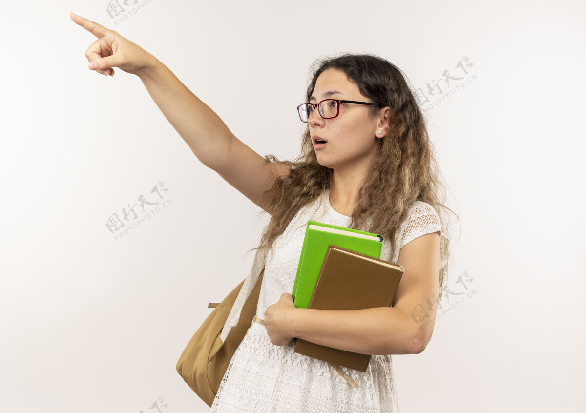 背印象深刻的年轻漂亮的女学生戴着眼镜 背着书包 指着书 看着一边孤立着印象女学生壁板
