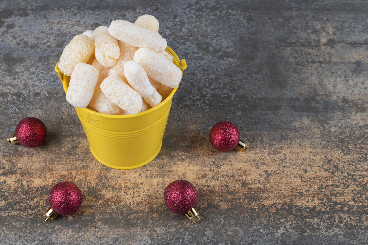 糖果玉米零食堆在一个桶旁边的圣诞饰品大理石表面美味玉米美味