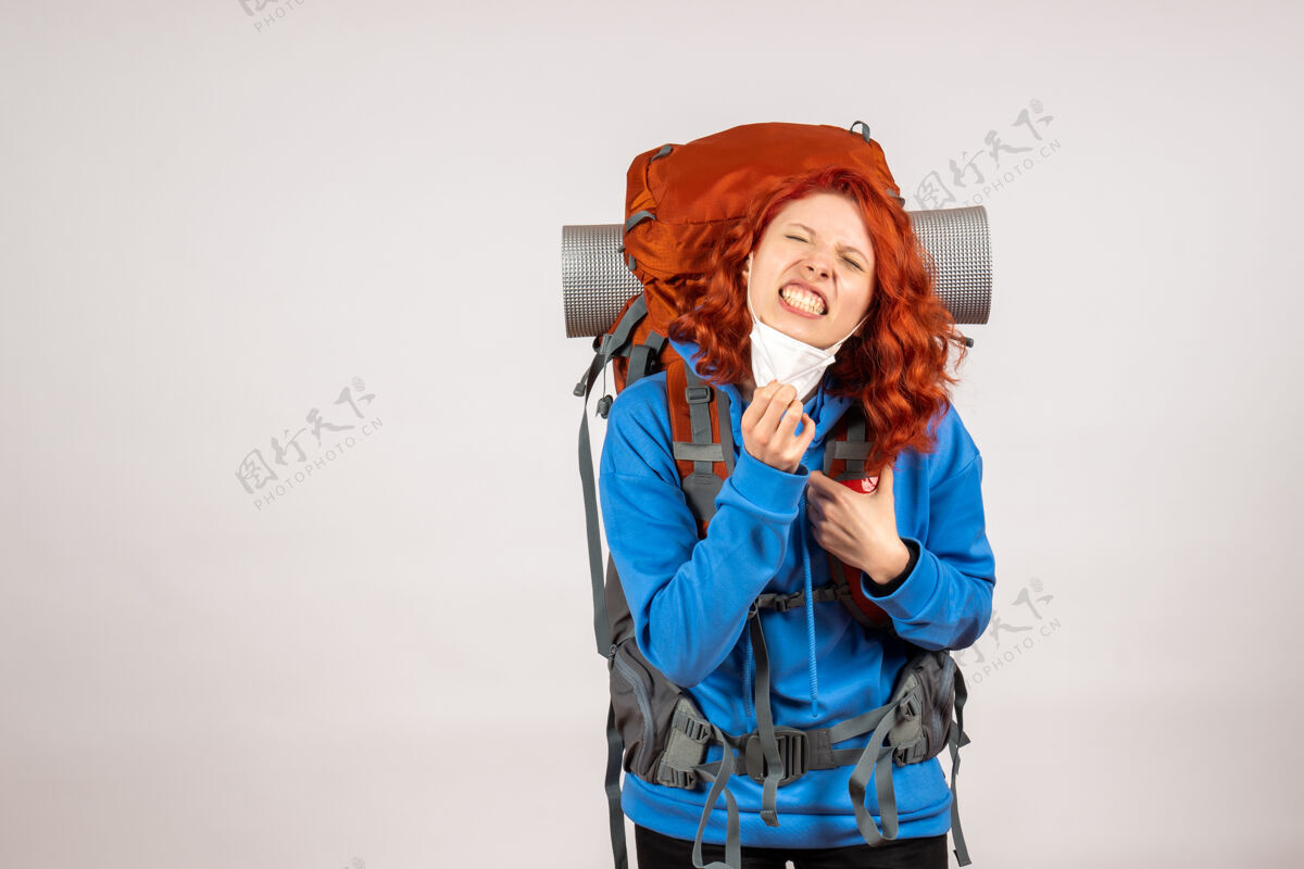 女人正面图戴着面具背着背包的女游客累了年轻伞山
