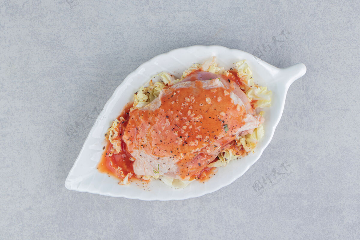 洋葱美味的辣味肉和番茄酱在盘子里 在蓝色的表面番茄酱好吃的肉