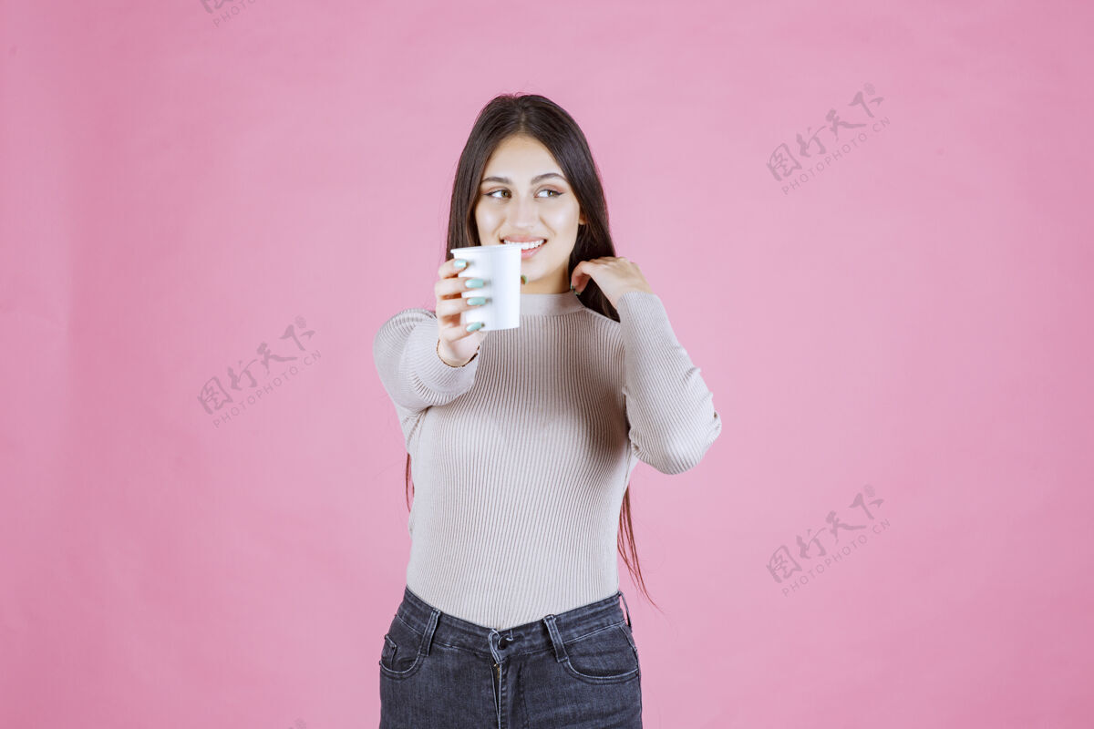 休闲一个拿着咖啡杯的女孩把它递给她的伴侣成人装束快乐