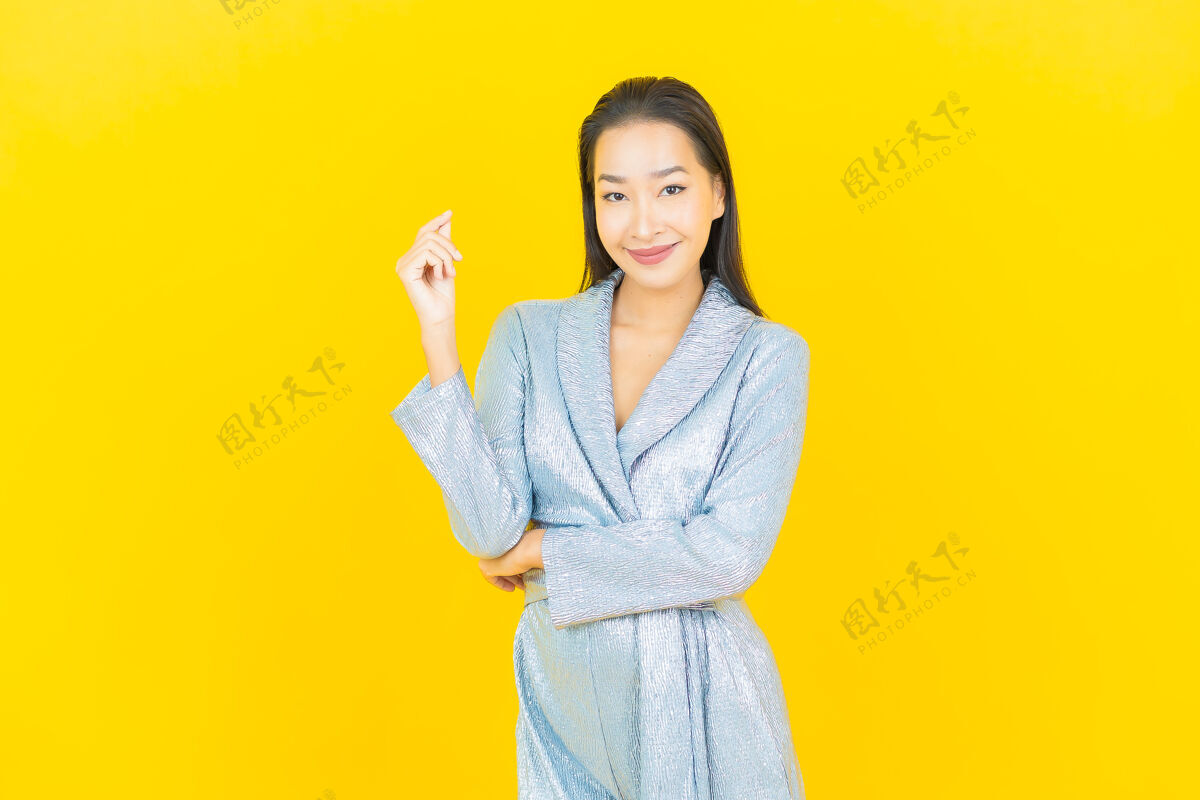 亚洲人在黄色的墙上描绘美丽的亚洲年轻女子微笑着行动紫色中国人休闲