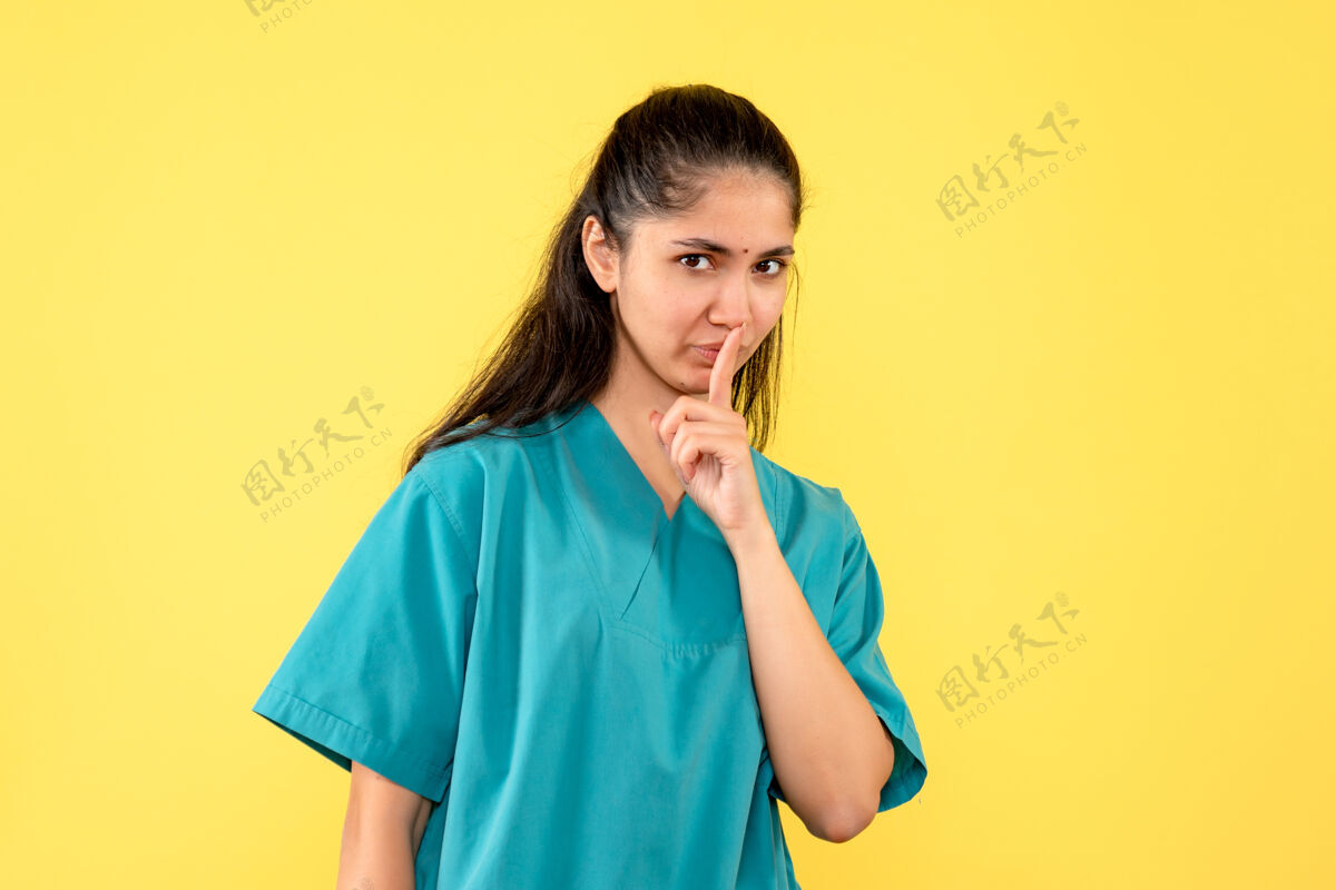 人前视图穿着制服的女医生正在做嘘标志站着黄色制服成人