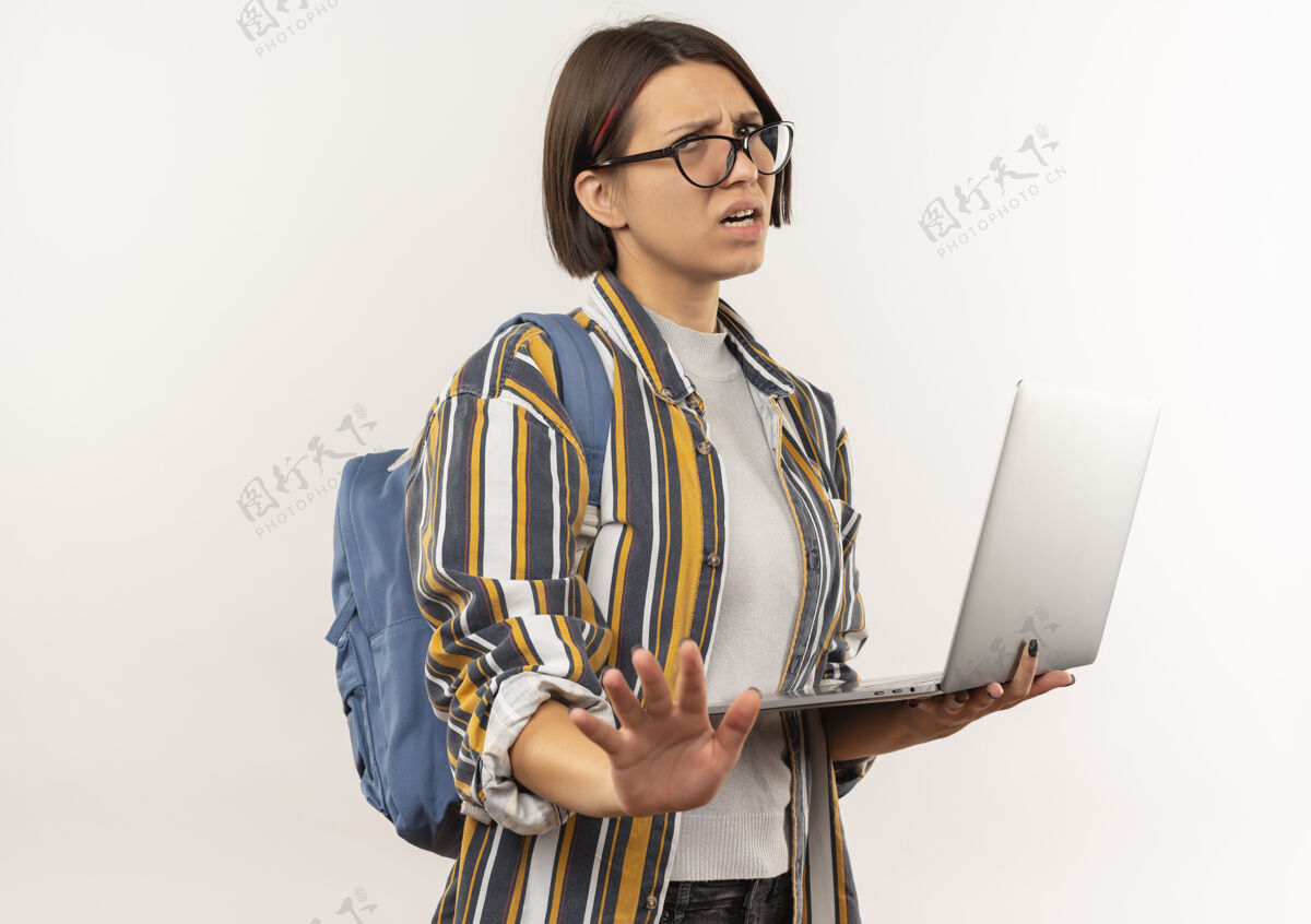 背部未出租的年轻女学生戴着眼镜 背着包拿着笔记本电脑 没有做任何手势 在白色背景上与复印空间隔离拿着眼镜女孩