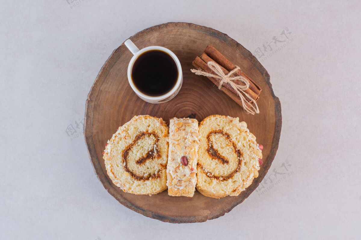 食物用蛋糕卷和肉桂在木板上盛一杯美式咖啡美味脂肪曲奇