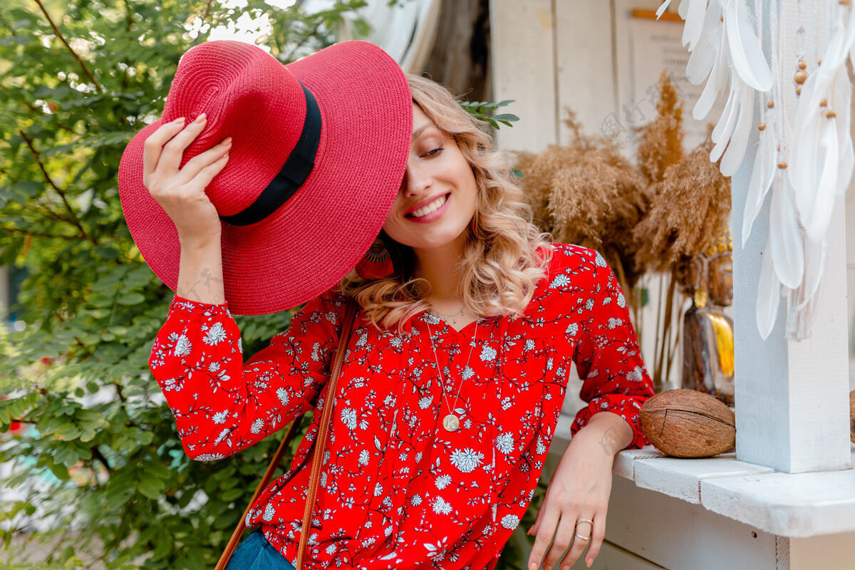 时尚迷人的时尚金发微笑的女人在草编红帽子和衬衫夏季时尚装咖啡厅配饰女人白色